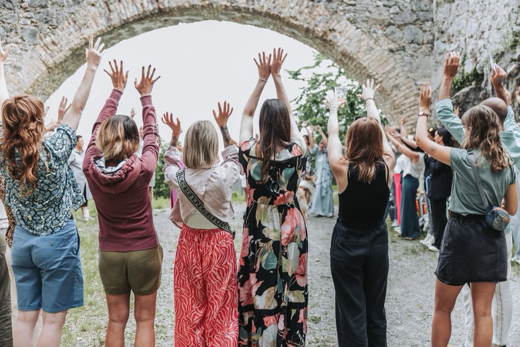 Group gathering with arms raised at a retreat